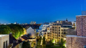 Nächtlicher Blick auf die beleuchtete Wohnanlage mit Innenhof am Nockherberg