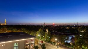 Abendlicher Ausblick mit beleuchtetem Kirchturm und Stadtsilhouette vom Nockherberg