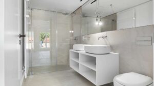 Badezimmer mit Doppelwaschtisch und Regendusche in einer Wohnung am Nockherberg