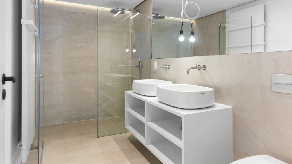 Duschbad mit Doppelwaschbecken und großer Glasdusche in einer Wohnung am Nockherberg
