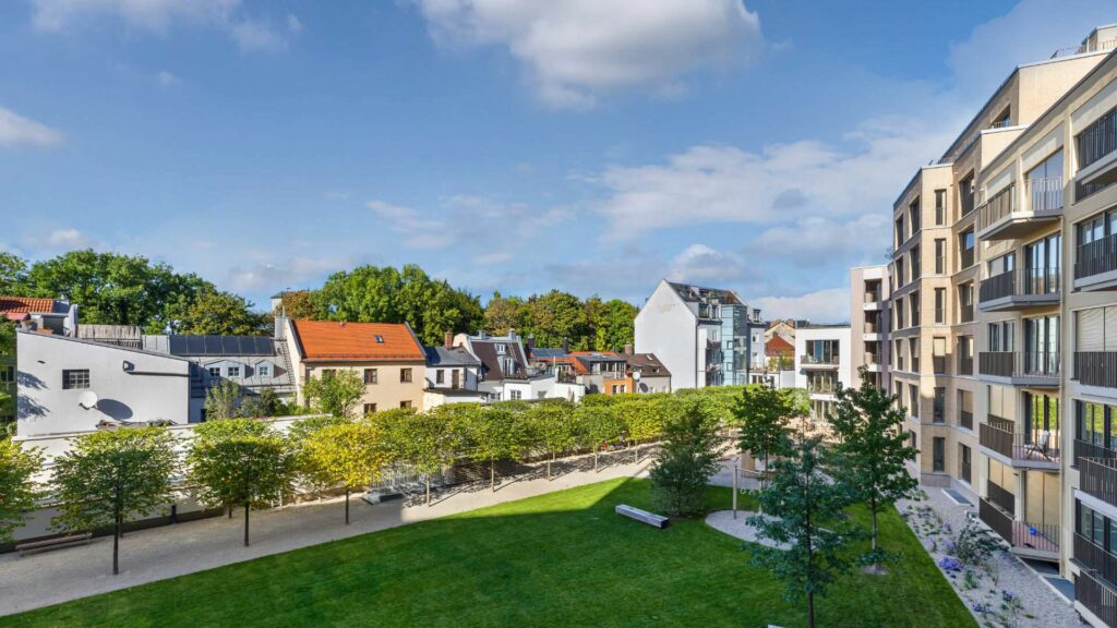 Ansicht der Wohnanlage mit Grünanlage und Nachbarhäusern am Nockherberg