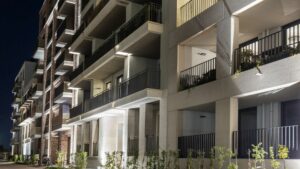 Nächtliche Fassade der Wohnanlage mit beleuchteten Balkonen am Nockherberg