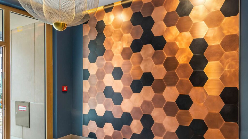 Dekorative Wandverkleidung mit Hexagon-Muster im Treppenhaus der Wohnanlage am Nockherberg