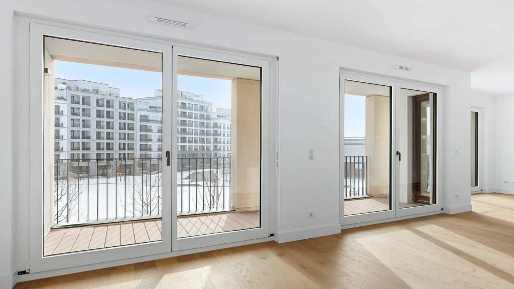 Wohnzimmer mit Balkonzugang und Blick auf die Nachbargebäude am Nockherberg