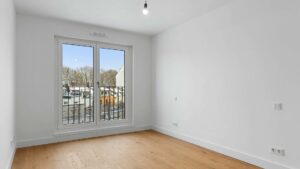 Leeres, helles Zimmer mit Parkettboden in einer Neubauwohnung am Nockherberg