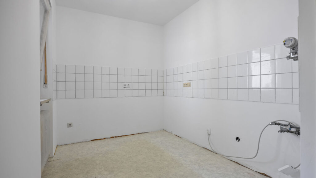 Empty kitchen space with partially laid tiles in raw condition, Pasing