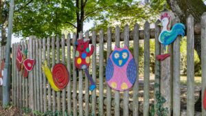 Wooden fence with colorful animal figures near a kindergarten in the area of Planegg house