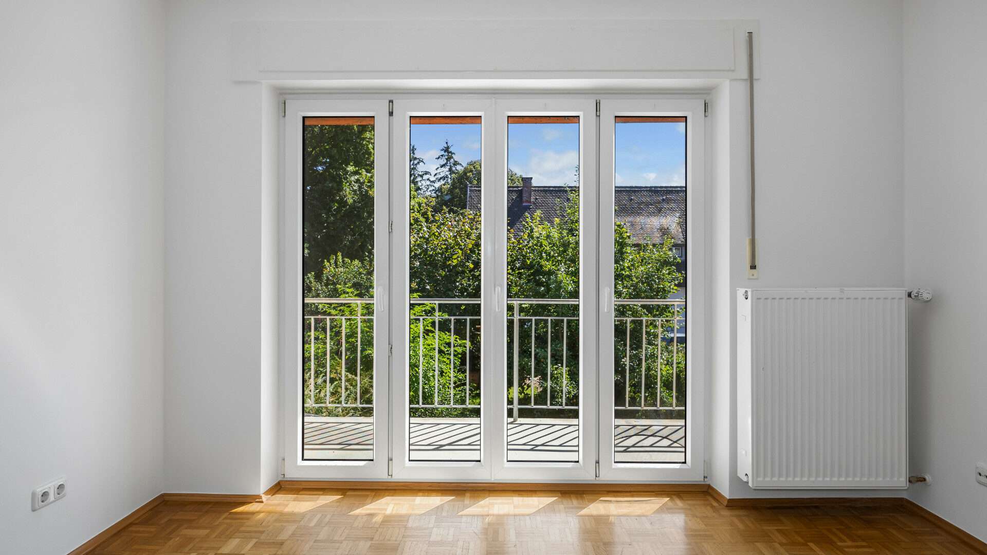 Empty bedroom with balcony door and beautiful green view in the Planegg house