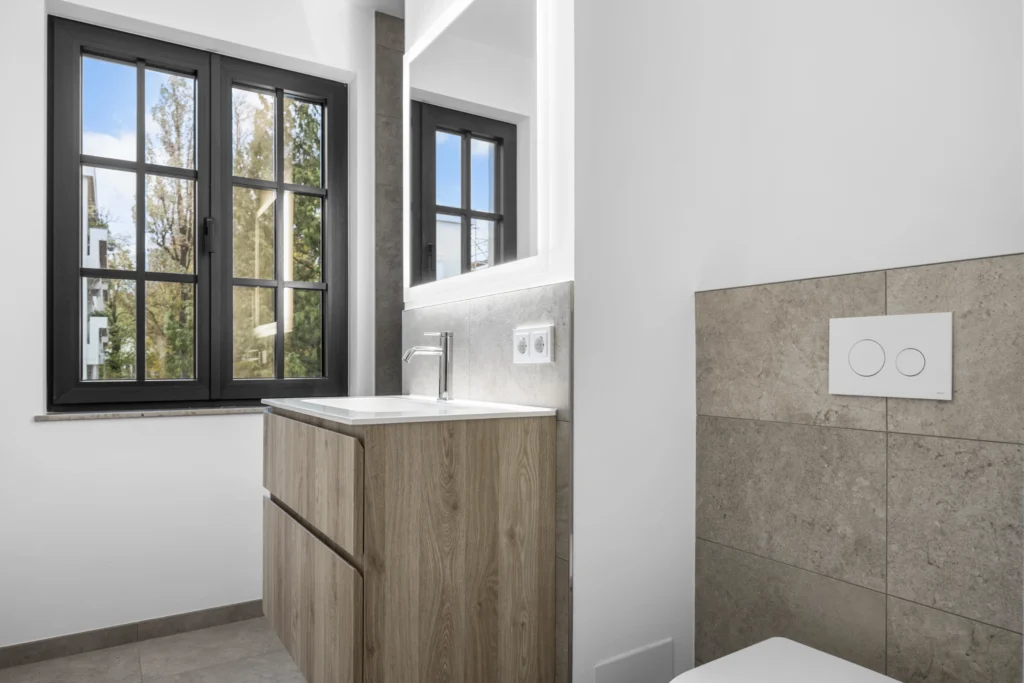 Bathroom with wooden vanity and natural stone tiles in rental apartment in Pöcking