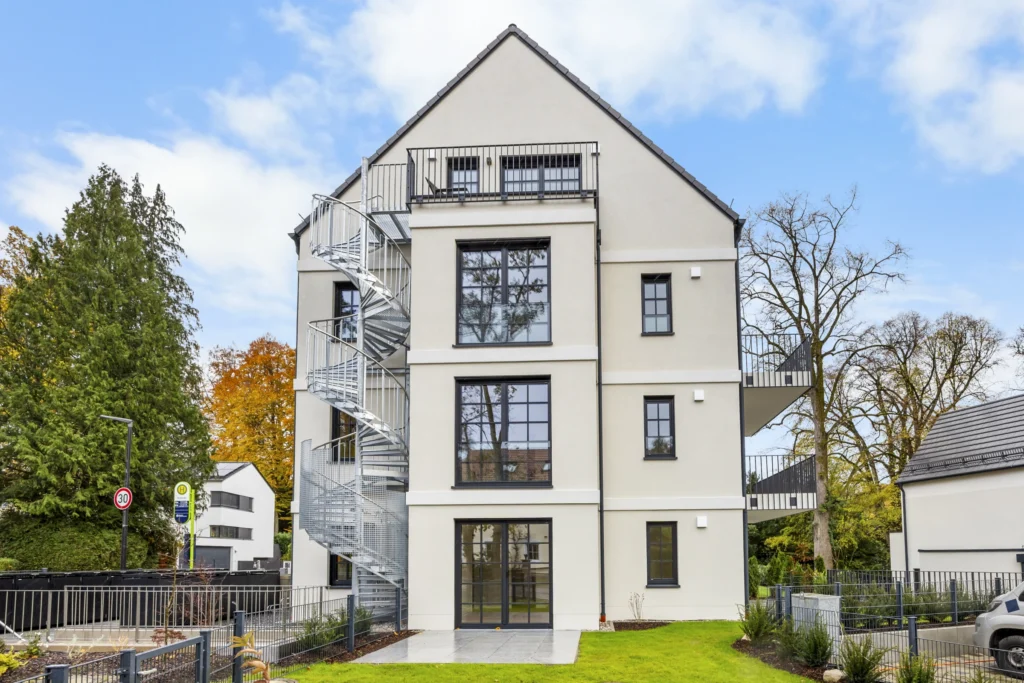 White apartment building with garden and large windows in Pöcking in daylight