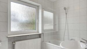 Bathroom with window, radiator, and tub edge in the Putzbrunn house