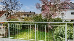 Balcony railing with a view of the garden and blooming tree in the house Putzbrunn