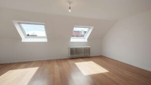 Empty attic room with two skylights and a wooden floor in the Putzbrunn house
