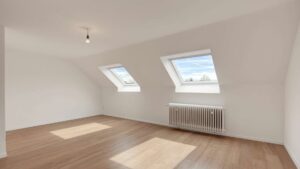 Empty attic room with two skylights and a wooden floor in the Putzbrunn house