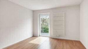 Empty room with patio door, radiator and hardwood floor in the Putzbrunn house