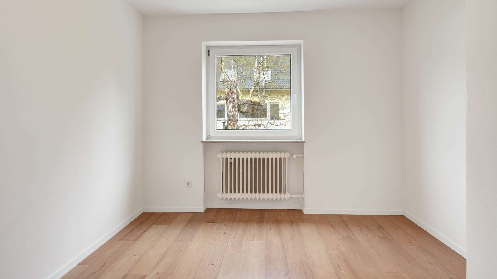 Empty room with window and light wooden floor in the Putzbrunn house