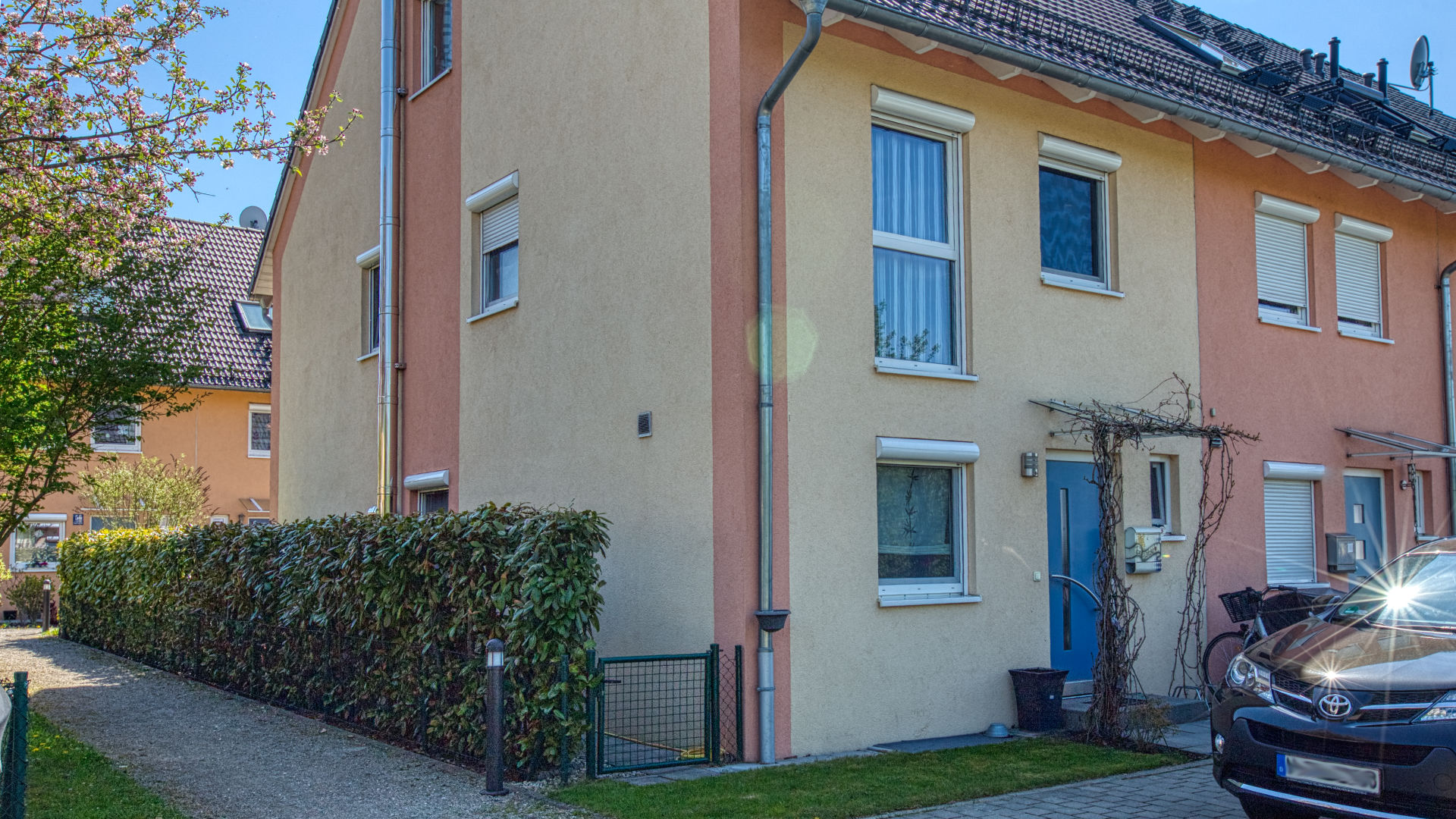 Reihenendhaus mit heller Putzfassade und gepflegtem Vorgarten, vermittelt von Rogers Immobilien München