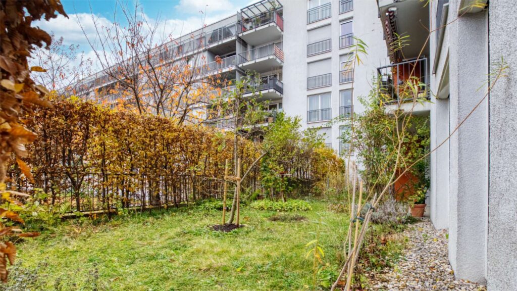 Community garden of the residential complex in Munich-Schwabing with a lawn and autumn hedge