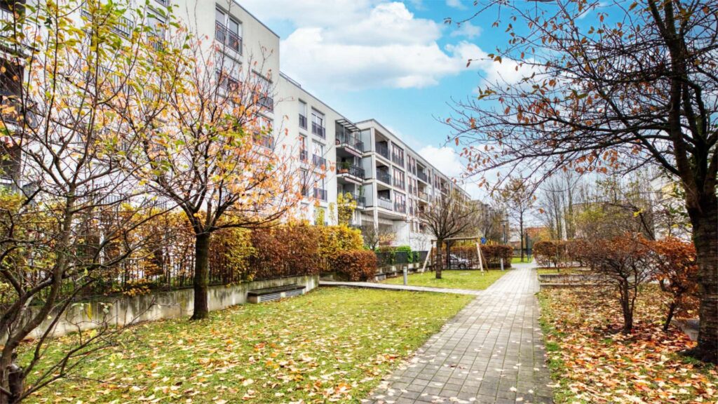 Exterior view of the residential complex in Munich-Schwabing with autumn planting and a paved path