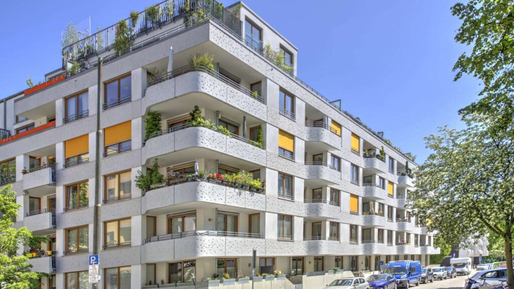 Straßenansicht der Wohnanlage in München-Sendling mit heller Fassade und Balkonen