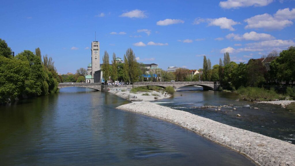 Isarufer in München-Sendling mit Blick auf Kirchtürme und Brücke