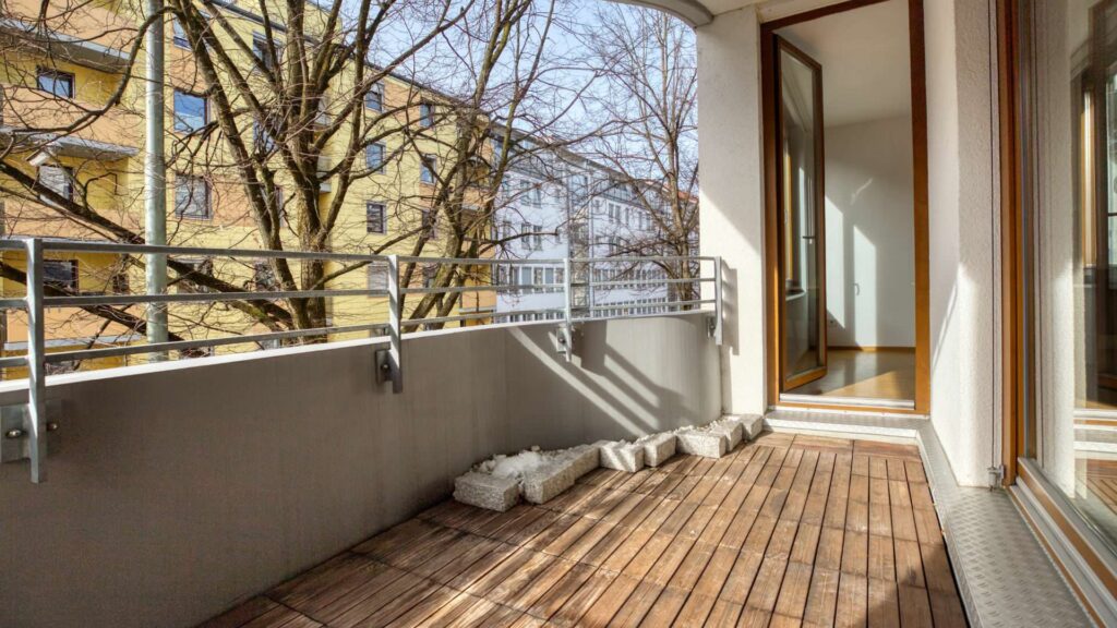 Balkon mit Holzboden und Blick auf Nachbargebäude in einer Wohnung in Sendling