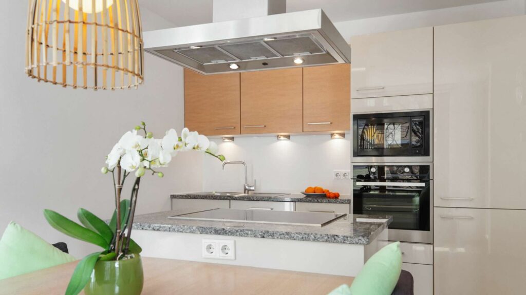 Einbauküche mit Granitarbeitsplatte und Backofen in einer Wohnung in Sendling