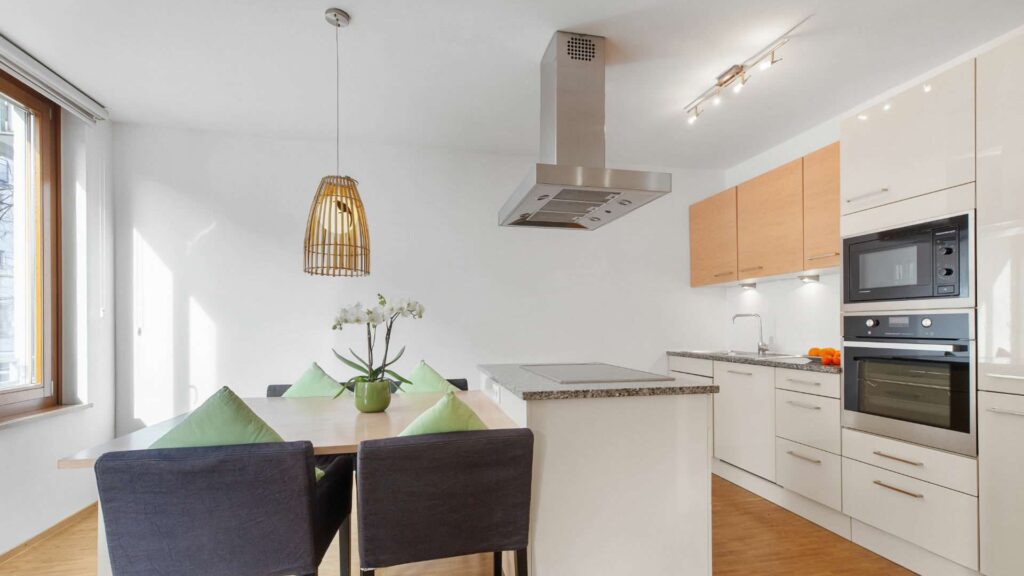 Küchenzeile mit Kochinsel und gedecktem Esstisch in einer Wohnung in Sendling