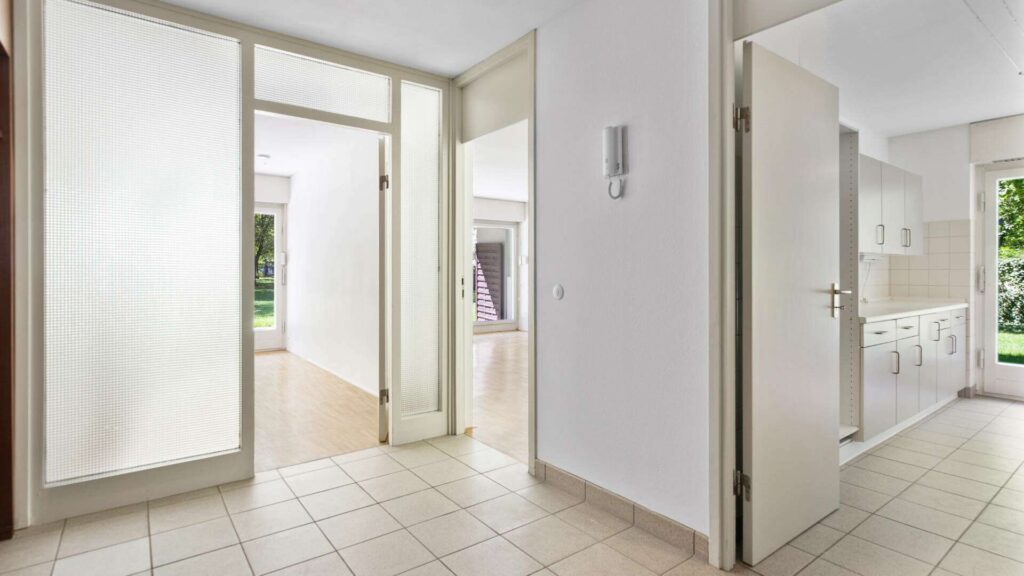 Diele der Wohnung in München-Solln mit Fliesenboden und Türen zu Küche und Wohnbereich
