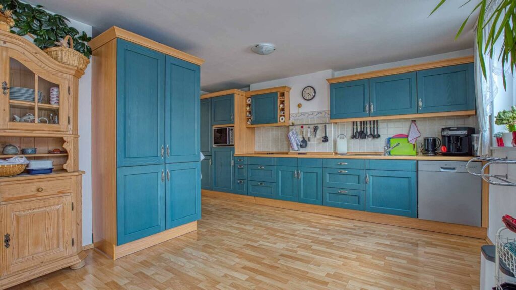 Rustic kitchen in Trudering with blue fronts, wooden elements, and a china cabinet.