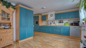 Rustic kitchen in Trudering with blue fronts, wooden elements, and a china cabinet.