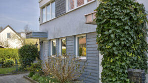 Hauseingang eines Reihenendhauses mit efeuberankter Fassade und kleinem Vorgarten in Unterhaching bei München