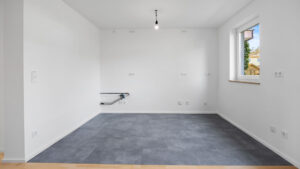 Leeres Zimmer mit dunkelgrauem Teppichboden und Fenster in Unterhaching