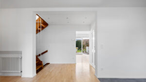 Leerer Wohnbereich mit Blick auf Holztreppe und Durchgang zur Terrasse in Reihenendhaus zur Miete Unterhaching
