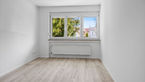 Leeres Zimmer mit Fenster, Blick auf Bäume und hellem Holzboden in Reihenendhaus zur Miete Unterhaching