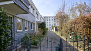 Gepflasterter Zugangsweg mit schmiedeeisernem Tor zu einem Reihenendhaus in Unterhaching bei München