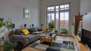 Wohnzimmer mit grauer Couch und Balkonzugang in einer Wohnung in Unterschleißheim