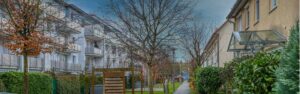 Straßenansicht der Wohnanlage mit Bäumen in Unterschleißheim, Rogers Immobilien