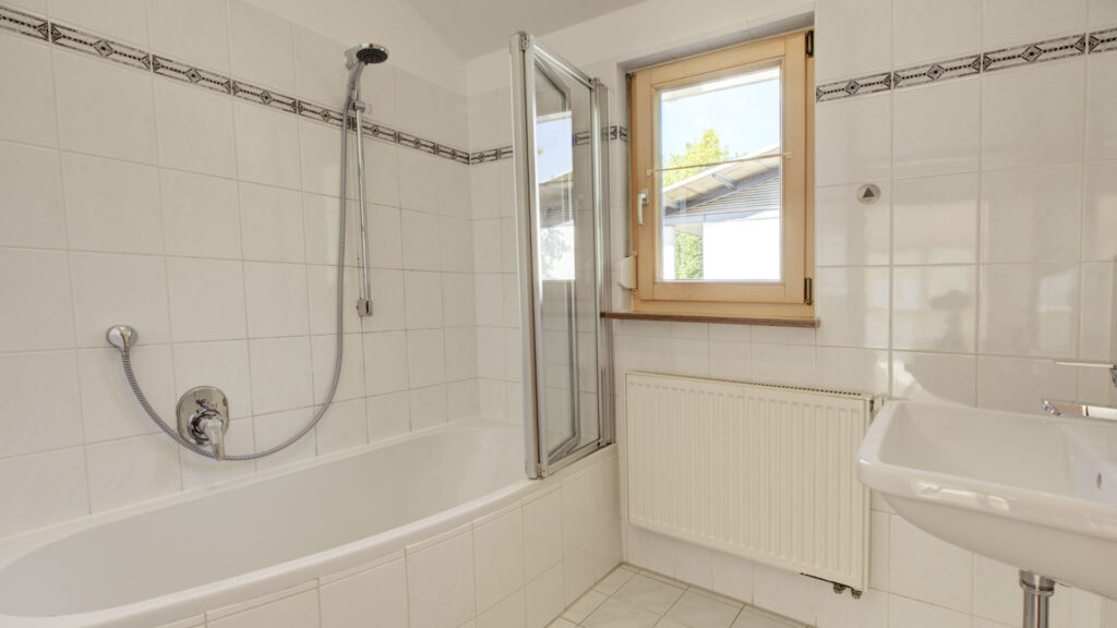 Tiled bathroom with bathtub and sink in an apartment building in Germering