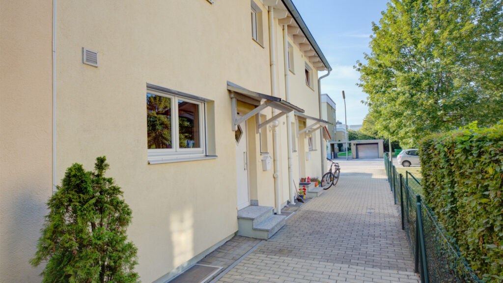 Entrance area of a terraced house with a paved driveway in Germering