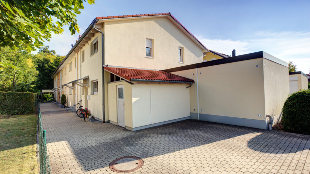 Front door with garage and paved driveway in Germering