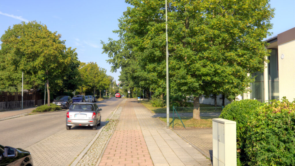 A quiet, tree-lined residential street near an apartment building in Germering