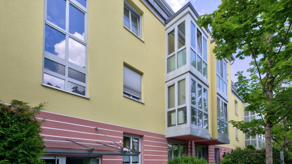 Fassade des Wohngebäudes in Berg am Laim mit gelbem Anstrich, Erker und Balkonen