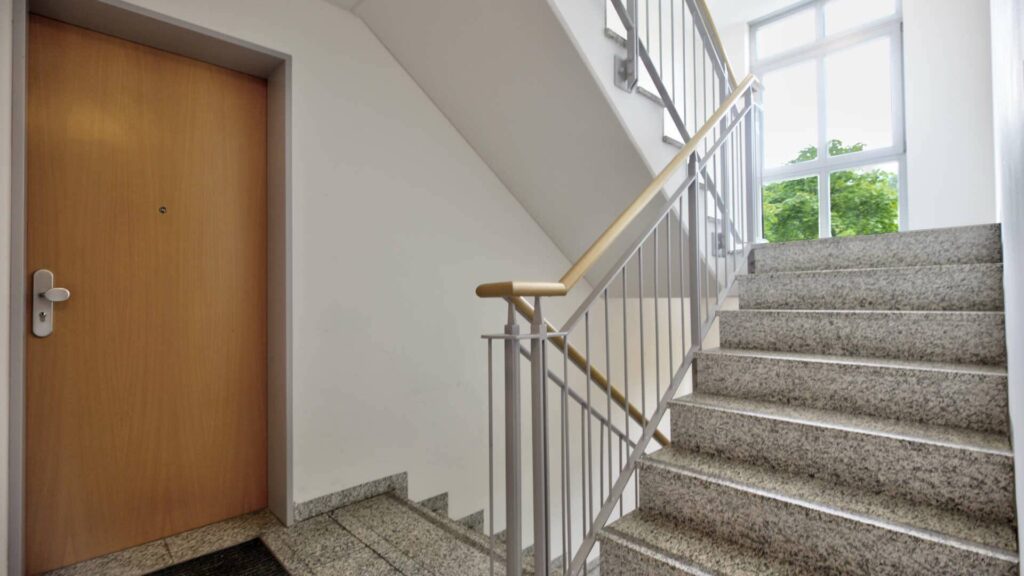 Treppenhaus des Wohngebäudes in Berg am Laim mit Marmorstufen, Geländer und Wohnungstür