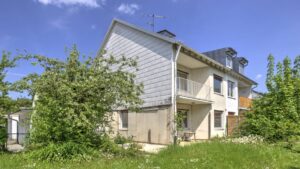 Giebelseite eines Hauses mit Rasenfläche und Strauchbepflanzung in München-Bogenhausen