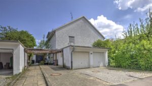 Gepflasterter Garagenhof mit zwei Doppelgaragen und Pergola bei einem Haus in München-Bogenhausen