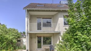Hausrückseite mit zwei übereinanderliegenden Balkonen und Terrasse eines Hauses in München-Bogenhausen