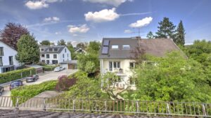 Blick von einem Balkon über Nachbarhäuser und Bäume im Stadtteil Bogenhausen in München