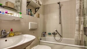 Existing bathroom with bathtub, shower curtain and sink in an apartment in Munich-Bogenhausen
