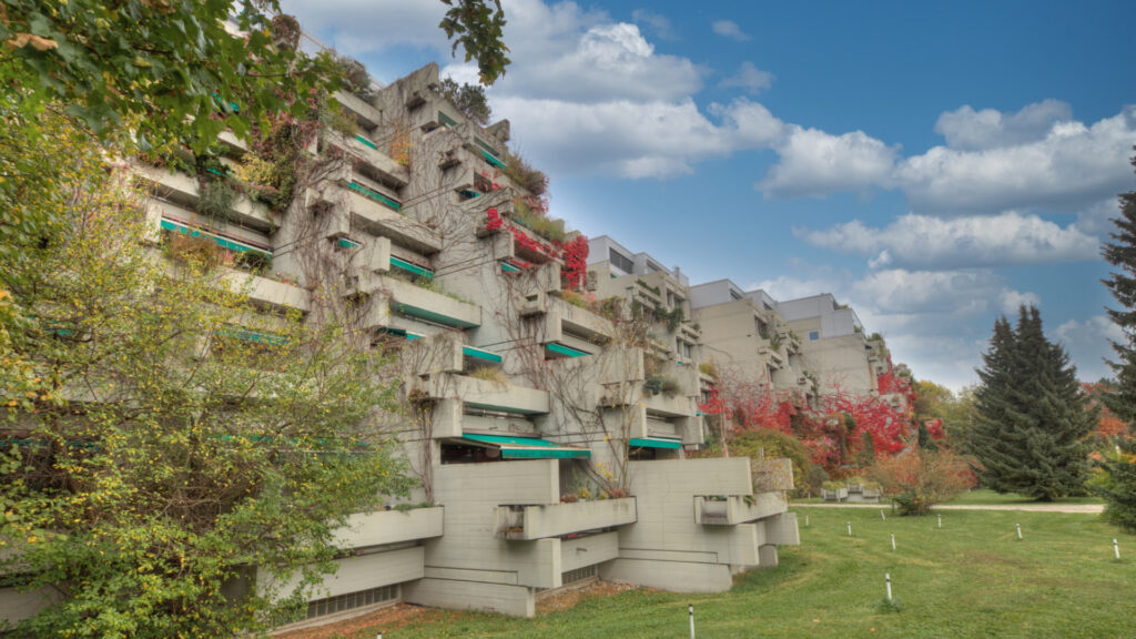 Markante gestufte Betonarchitektur der Terrassenhausanlage mit Bäumen in München-Bogenhausen